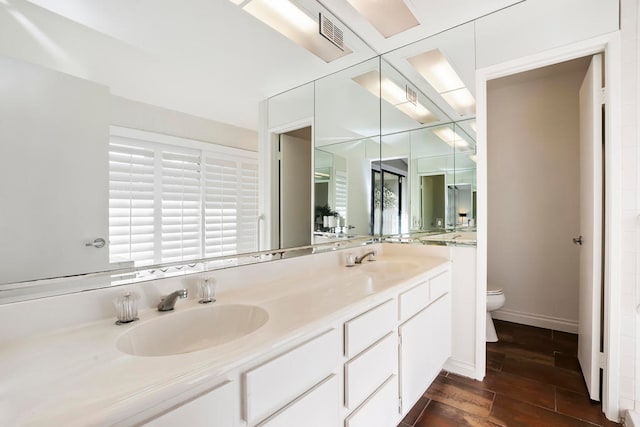 bathroom with wood-type flooring, vanity, and toilet