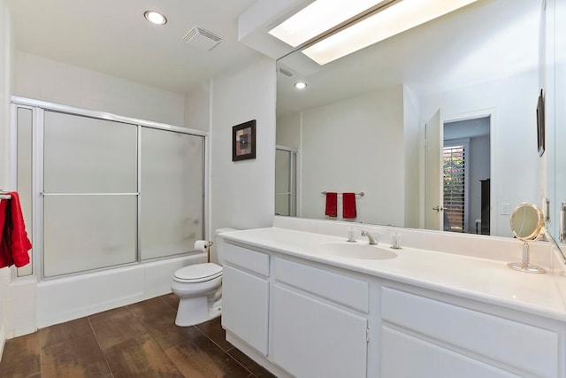 full bathroom featuring vanity, shower / bath combination with glass door, toilet, and wood-type flooring