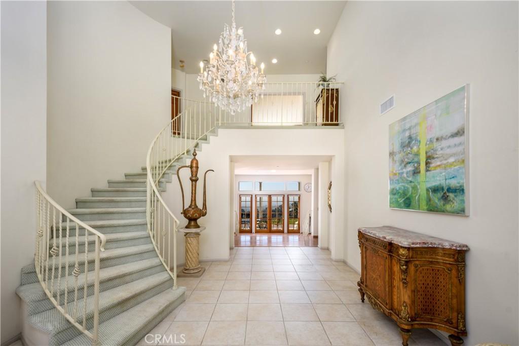 foyer entrance with a high ceiling, light tile patterned floors, and an inviting chandelier