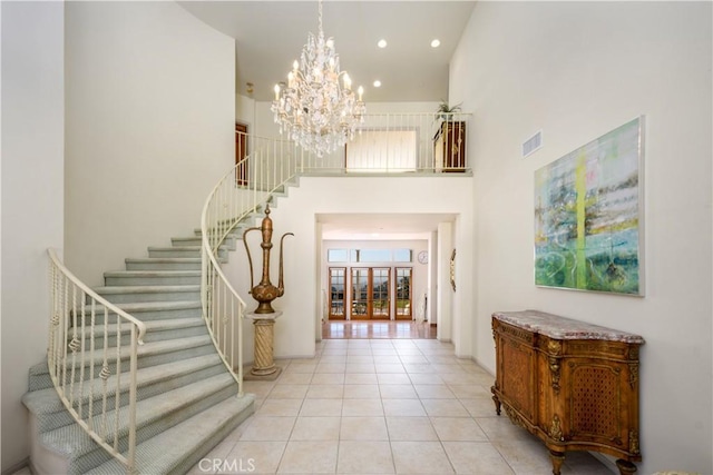 foyer entrance with a high ceiling, light tile patterned floors, and an inviting chandelier