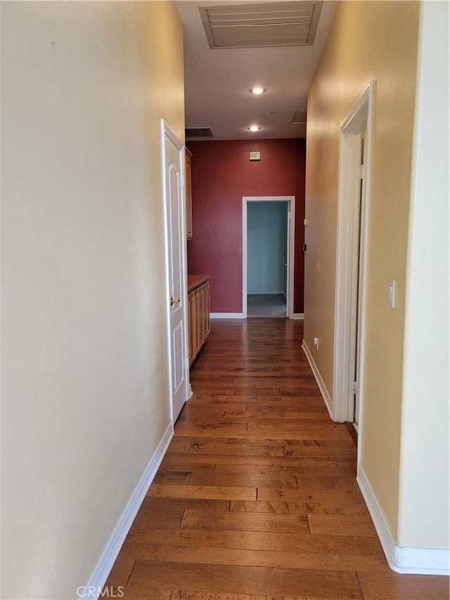 corridor with dark hardwood / wood-style flooring