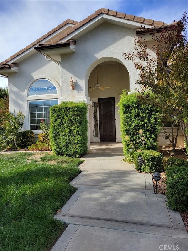 entrance to property featuring ceiling fan