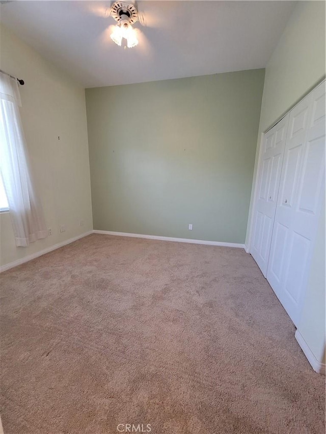 unfurnished bedroom with light carpet, a closet, and ceiling fan