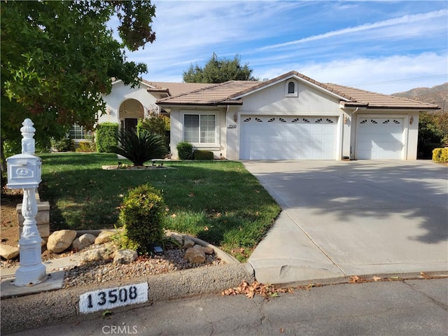 view of front of home with a front yard and a garage