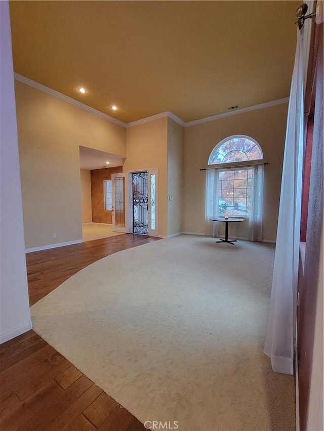 unfurnished living room featuring hardwood / wood-style flooring and ornamental molding