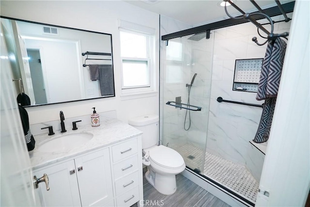 bathroom with vanity, toilet, a shower with door, and wood-type flooring