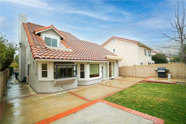 back of house with a patio area and a yard