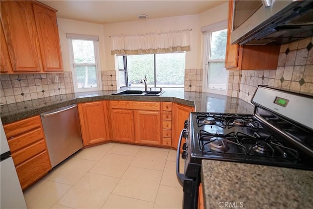 kitchen featuring ventilation hood, range with gas cooktop, sink, light tile patterned floors, and dishwasher