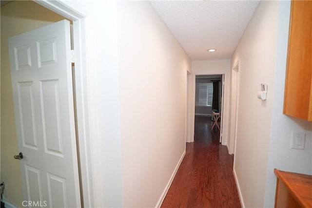 hall featuring dark wood-type flooring and a textured ceiling