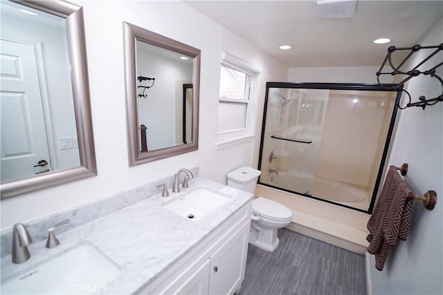 full bathroom with vanity, toilet, and enclosed tub / shower combo