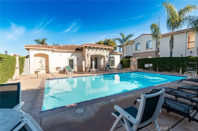 rear view of house featuring a patio area and a community pool