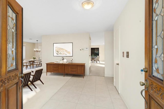 tiled entrance foyer with an inviting chandelier