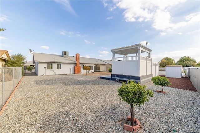 rear view of property with cooling unit and a pergola