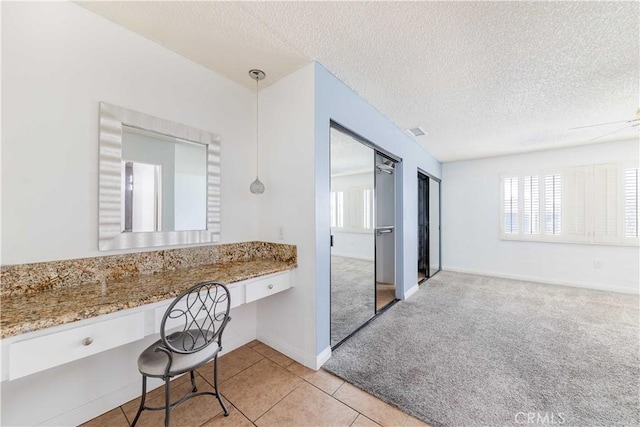 bathroom with ceiling fan, tile patterned flooring, and a textured ceiling