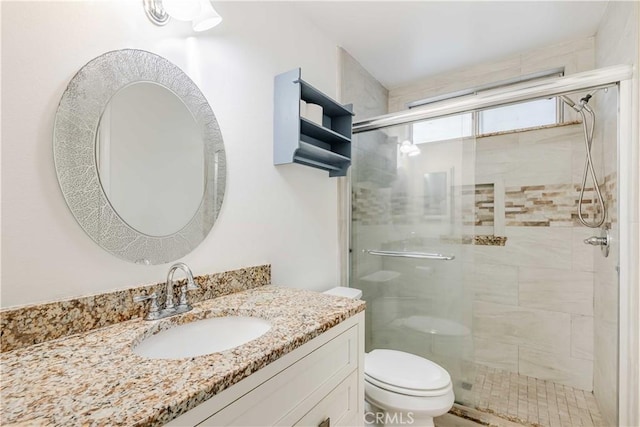 bathroom with toilet, vanity, and an enclosed shower