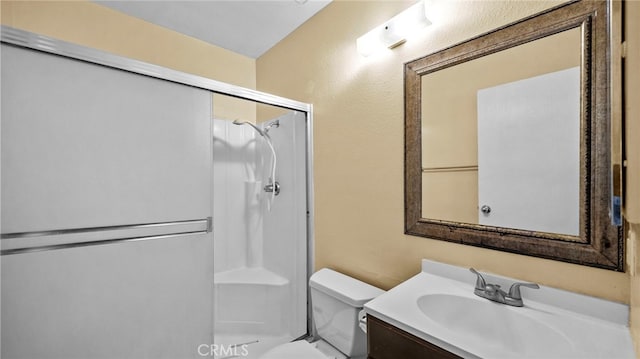 bathroom featuring toilet, walk in shower, and vanity