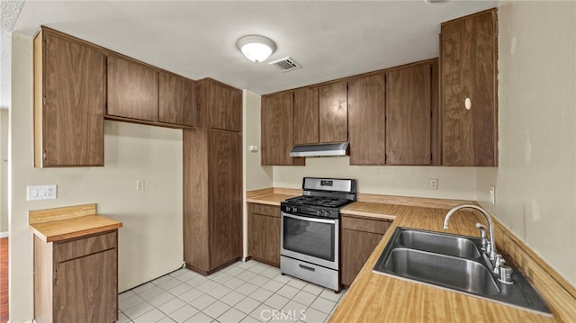 kitchen featuring light tile patterned floors, sink, and stainless steel range with gas stovetop