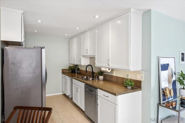 kitchen featuring white cabinets, appliances with stainless steel finishes, light tile patterned flooring, and sink