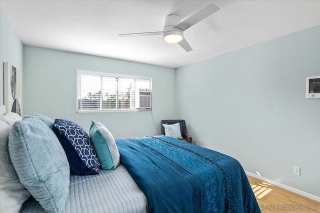 bedroom featuring hardwood / wood-style floors, ceiling fan, and cooling unit