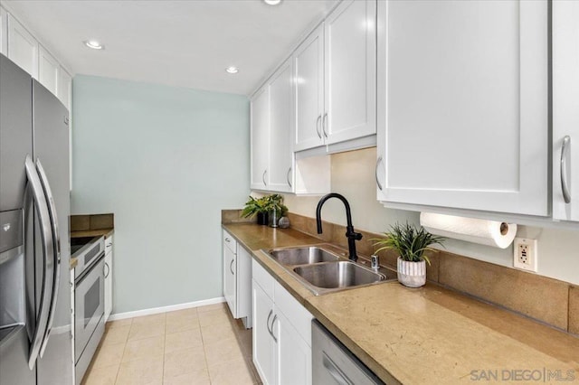 kitchen featuring white cabinets, appliances with stainless steel finishes, light tile patterned flooring, and sink