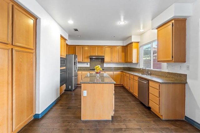 kitchen with sink, a center island, dark wood-type flooring, tasteful backsplash, and appliances with stainless steel finishes