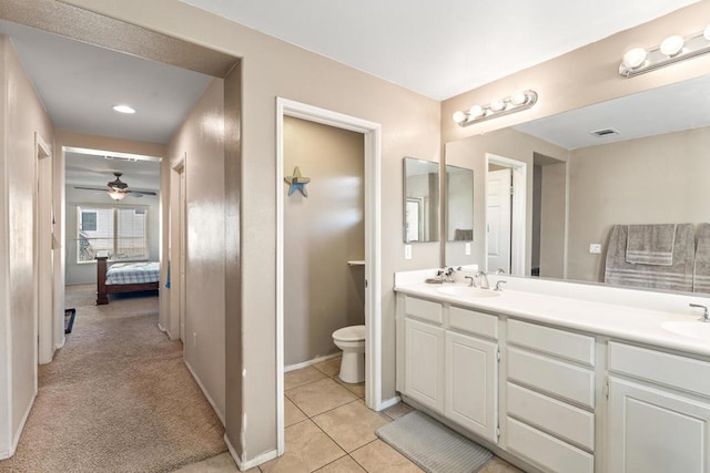 bathroom with tile patterned flooring, vanity, toilet, and ceiling fan