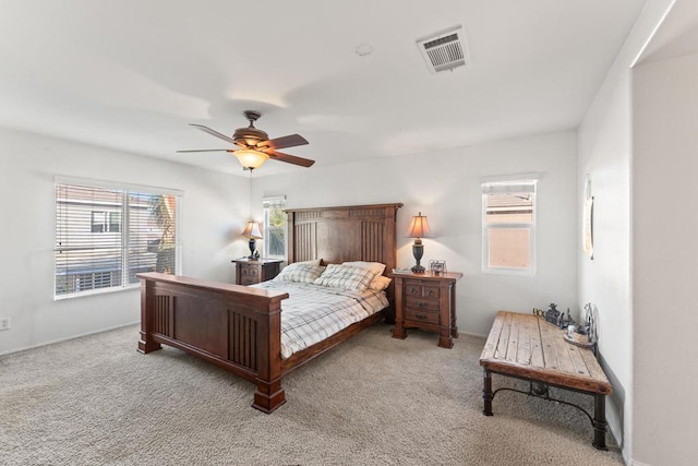 carpeted bedroom with multiple windows and ceiling fan