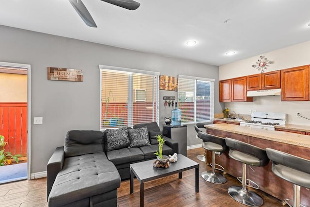 kitchen with white gas range oven, ceiling fan, and dark wood-type flooring