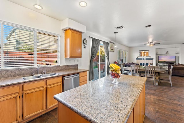 kitchen with dark hardwood / wood-style flooring, stainless steel dishwasher, ceiling fan, sink, and a kitchen island