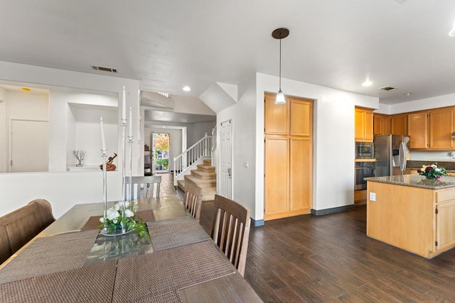 dining room with vaulted ceiling and dark wood-type flooring