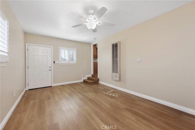 empty room with ceiling fan and light hardwood / wood-style flooring