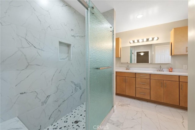 bathroom with vanity and tiled shower