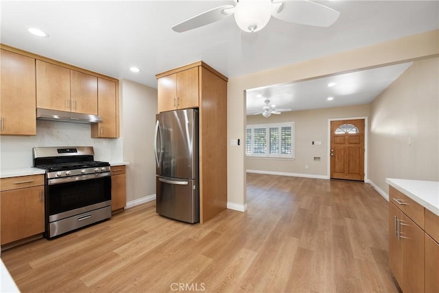 kitchen with ceiling fan, stainless steel appliances, and light hardwood / wood-style flooring