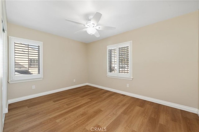 empty room with light wood-type flooring, ceiling fan, and a healthy amount of sunlight