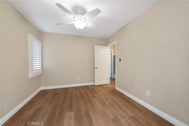 empty room with ceiling fan and light hardwood / wood-style floors