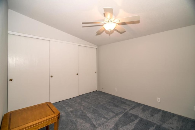 carpeted bedroom with ceiling fan, a closet, and vaulted ceiling