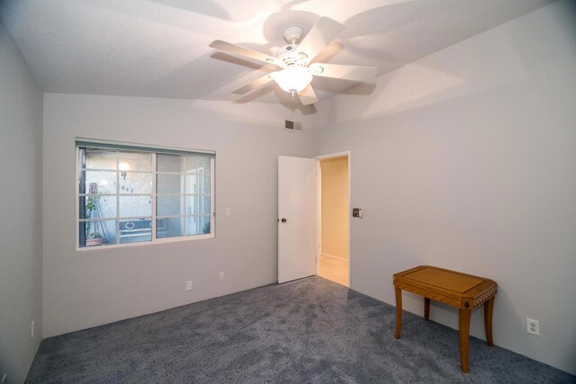 empty room with ceiling fan and dark carpet