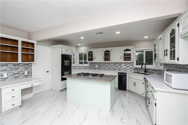 kitchen with tasteful backsplash, double oven, stainless steel gas cooktop, sink, and a center island