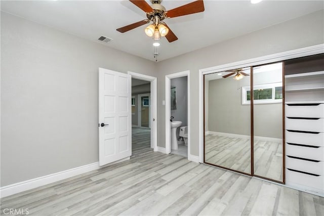 unfurnished bedroom featuring connected bathroom, light hardwood / wood-style floors, a closet, and ceiling fan