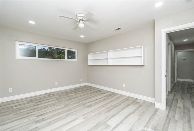 empty room with ceiling fan and light hardwood / wood-style floors