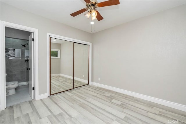 unfurnished bedroom with ceiling fan, ensuite bathroom, light hardwood / wood-style flooring, and a closet