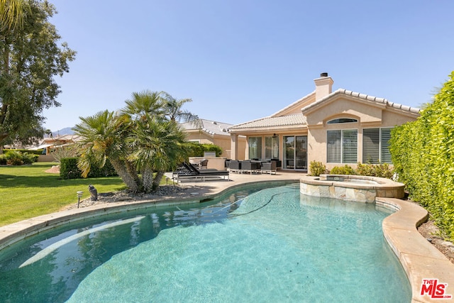 view of swimming pool with a patio area, a yard, and an in ground hot tub