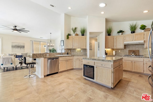 kitchen featuring stainless steel appliances, ceiling fan, sink, light brown cabinets, and a center island