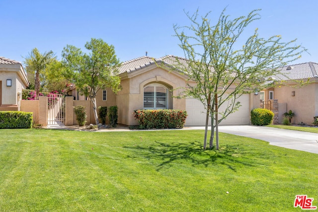 mediterranean / spanish home with a garage and a front lawn