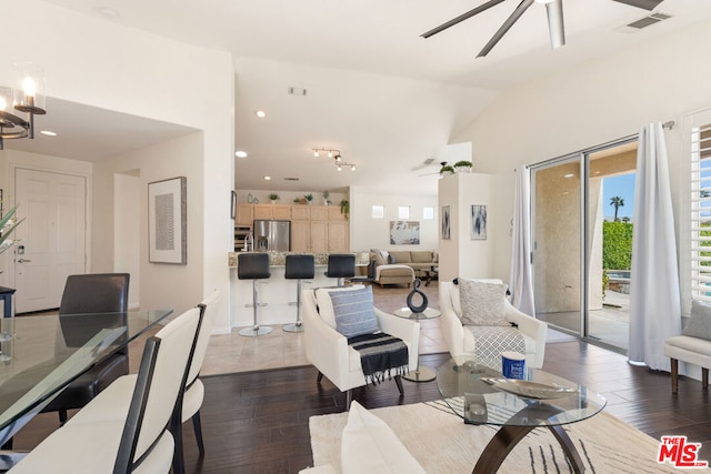 living room with dark hardwood / wood-style floors, lofted ceiling, and ceiling fan with notable chandelier