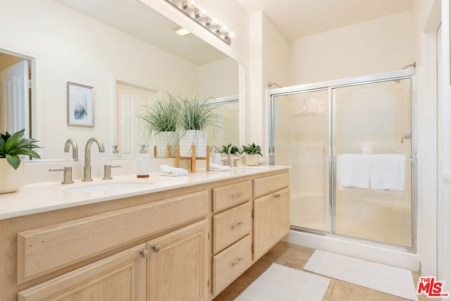 bathroom with tile patterned floors, vanity, and a shower with door