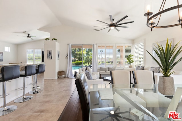 tiled living room with ceiling fan with notable chandelier and vaulted ceiling