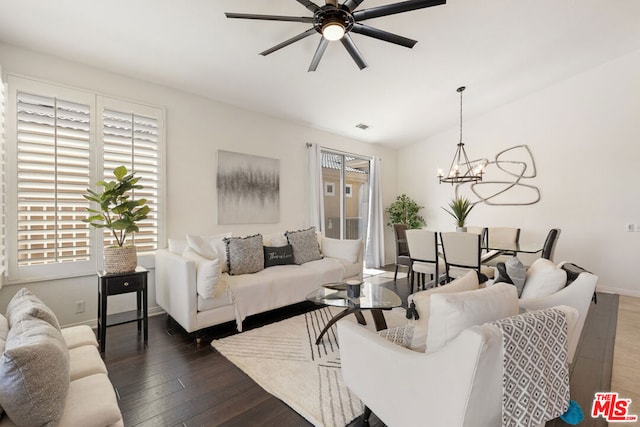 living room featuring vaulted ceiling, dark hardwood / wood-style flooring, and ceiling fan with notable chandelier