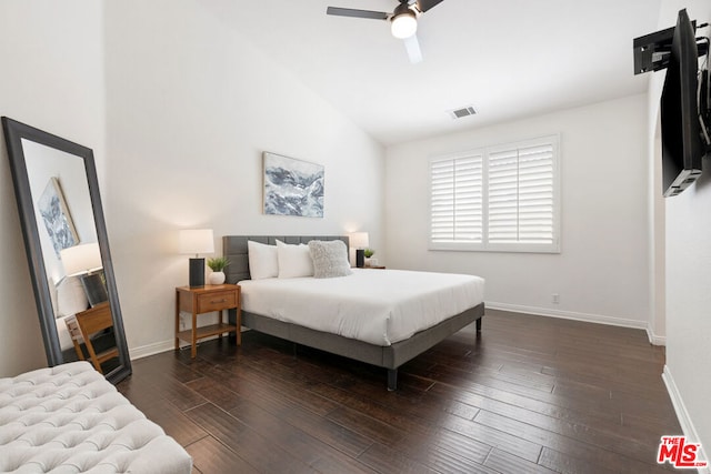 bedroom featuring dark hardwood / wood-style floors, vaulted ceiling, and ceiling fan