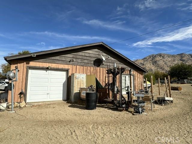 exterior space with a mountain view, an outdoor structure, and a garage